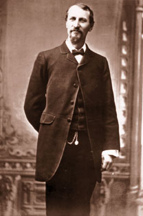 Fashionable Fred Harvey wears a frock coat, vest and pocket watch.